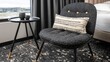 © Pande - Modern armchair with decorative pillow next to a small side table by the window.