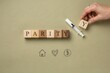 © Fahad - A hand holds wooden block to complete parity concept with marker on table