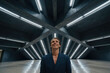 © f_bossa - Man in dark navy blazer smiles upward within a brutalist concrete structure featuring geometric ceiling beams and integrated linear lamps. Symmetrical architectural lines guide the eye toward center