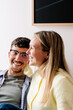 © Adrian Rodd/Stocksy - A happy couple laughs as a blonde woman embraces the man from behind.