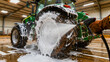 © Vali - Pressure washing foam from a large tractor wheel. Agricultural worker cleaning farm machinery in a hangar. Equipment maintenance concept for agribusiness marketing and industrial service ads.