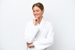 © luismolinero - Young pretty blonde woman in bathrobe isolated on white background looking to the side and smiling