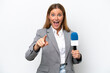 © luismolinero - Young caucasian tv presenter woman isolated on white background surprised and pointing front