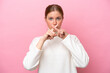 © luismolinero - Young caucasian woman isolated on pink background showing a sign of silence gesture