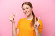 © luismolinero - Young caucasian woman holding invisaging isolated on pink background smiling and showing victory sign