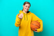 © luismolinero - Young caucasian woman isolated on blue background playing basketball and doing coming gesture