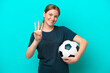 © luismolinero - Young football player woman isolated on blue background happy and counting three with fingers