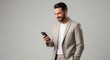 © twilight mist - Smiling Young Businessman in Beige Blazer Using Smartphone for Communication and Social Media on Neutral Gray Background