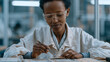 © forenna - Ethiopian woman assembles lithium battery cell modules at a manufacturing workstation, placing electrode stacks with precision tweezers, wearing anti-static wrist straps and
