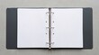 © BILKIS BEGUM - Open empty three-ring binder folder with metal rings and blank white pages on a neutral gray office background stationary organizer