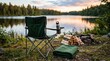© Maria - A folding camping chair with a built-in cup holder positioned beside a peaceful lakeshore, accompanied by a reusable water bottle, a neatly folded green blanket, and a stack of firewood.