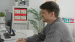 © Krakenimages.com - Woman with stethoscope writing on clipboard while patient smiles across a desk with computer and monitor in building; reassurance.