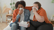 © Krakenimages.com - Man and plus size woman share tissues and orange blanket as woman blows nose with tissue in studio; compassion support togetherness.