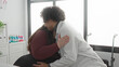 © Krakenimages.com - Woman patient hugs doctor with stethoscope in clinic building during seated examination, smiling and with supportive touch; comfort trust support.