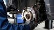© Natallia Simanchyk - A mechanic in gloves uses a flashlight to inspect a vehicle brake disc assembly. Professional auto maintenance and safety check in a garage. Useful for automotive service websites.