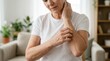 © Panpatsa - A mature woman scratching her arm due to sensitive or itchy skin.