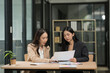 © Thitisak - Meeting and analyzing business plan by two female executives in modern office