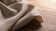 © Sergey - natural beige linen fabric softly draped across light oak tabletop, warm morning sunlight, realistic woven texture, elegant minimalist composition
