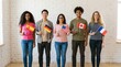 © Stock Fire - Five diverse young adults standing in a row, each holding a small national flag against a brick wall