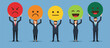 © sjeixh - Diverse business team holding colorful smiley face circle signs representing different levels of mood and emotional feedback at modern workplace survey design.