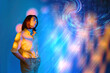 © VISTA by Westend61 - Mature woman looking at surreal digital light projection