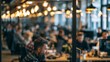 © Harry - A busy office cafeteria with people sitting at tables and eating lunch together