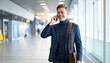© shahabat - Smiling businessman in a blue suit walking and talking on his smartphone in a modern airport terminal, business travel and communication concepts