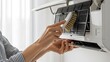 © HariBudi - Woman Cleaning Dusty Air Conditioner Filter With Brush For Indoor Health
