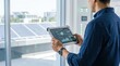 © William - Engineer monitoring solar panel energy performance on tablet app inside smart building with sustainability green technology concept