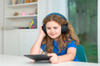© Volodymyr - Child tablet lesson creates online learning. Child headphones help focused study. Smiling learner uses child screen. Home classroom keeps child education active.