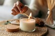 © gankevstock - Close up of hands lighting a white candle with a match for cozy ambiance