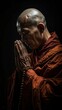 © firman - Buddhist monk in prayer meditation under dim light.