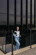 © ADDICTIVE STOCK - Businesswoman walking confidently outside office building