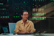 © Zamrznuti tonovi - Woman programmer working on laptop in server room, managing data security and information technology infrastructure