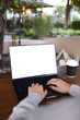 © Farknot Architect - Vertical mockup image of a woman working and typing on laptop computer with blank white desktop screen in cafe