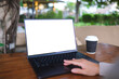 © Farknot Architect - Mockup image of a woman working and touching on laptop computer touchpad with blank white desktop screen in cafe