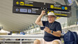 © Nazareno - Man celebrating win on smartphone in airport terminal
