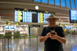 © Nazareno - Man checking flight information using smartphone at airport
