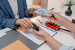 © PHOTO4U - Car purchase transaction with payment, contract signing, key handover, and customer agreement in a modern dealership office, representing automotive sales, business finance, and professional service.