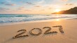 © Pixels Stock - New Year inscription 2027 written in sand on beach at sunset with ocean waves and calm water suggesting peaceful start of future celebration and happy holidays.
