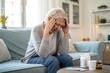© Евгений Порохин - Senior woman sits, head in hands, appearing distressed