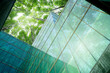 © Fahroni - Eco-friendly building in modern city. Sustainable glass office building with trees for reducing CO2. Green architecture. Building with green environment. Sustainability corporate. Net zero emissions.
