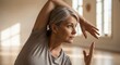 © Angavlan - Elderly woman practicing yoga in serene studio, demonstrating tranquil movements and mindful posture. This yoga class for seniors emphasizes flexibility and balance,