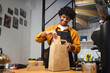© Westend61 - Smiling barista packing takeaway order at coffee shop