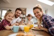 © Bojan - Happy Parents Having Breakfast Kids Kitchen Table