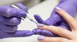 © Bali - Close-up of a manicurist applying lavender nail polish with a decorative jewel accent