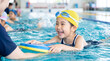 © Blue Studio - スイミングスクールでコーチから水泳を教わる小学生の子ども