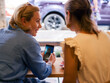 © Milles Team/Stocksy - Friends discussing photo on smartphone at cafe