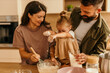 © La Famiglia - Happy family baking together messy flour fun