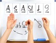 © Ridwan - Hands Practicing Vision Test Symbols on Whiteboard in Clinical Setting